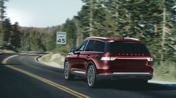 A 2024 Lincoln Aviator® SUV is being driven on a winding mountain road | Mathews Lincoln in Marion OH