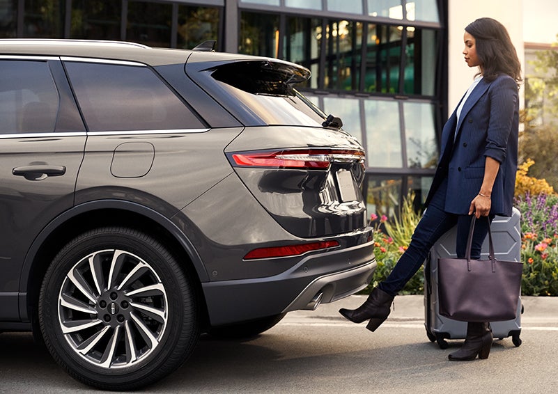 A woman with her hands full uses her foot to activate the available hands-free liftgate. | Mathews Lincoln in Marion OH