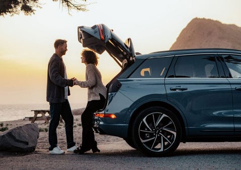 A couple share a moment together outside a 2025 Lincoln Corsair® SUV near the open liftgate. | Mathews Lincoln in Marion OH