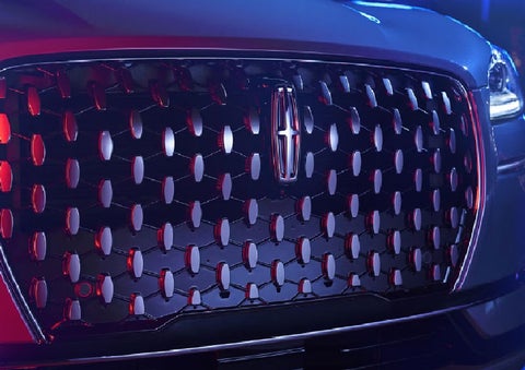 The grille of a 2025 Lincoln Corsair® SUV reflects neon light at night. | Mathews Lincoln in Marion OH