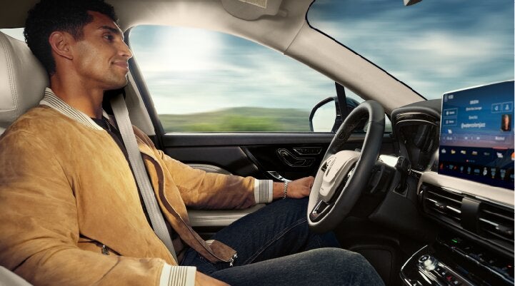 A person is shown using Lincoln BlueCruise hands-free highway driving technology on a divided highway called a Hands-Free Blue Zone. | Mathews Lincoln in Marion OH