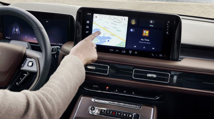 A person is tapping the center display touchscreen of a 2026 Lincoln Aviator® SUV. | Mathews Lincoln in Marion OH