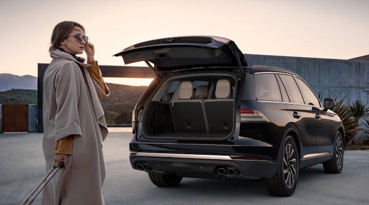 A woman approaches a 2026 Lincoln Aviator® SUV with its rear liftgate open. | Mathews Lincoln in Marion OH